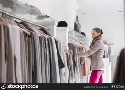 Side view of woman choosing sweater in store