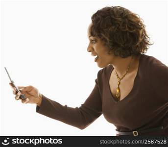 Side view of woman looking at cellphone with happy expression.