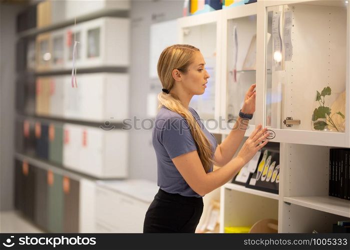side view of women looking for something on bookshelf
