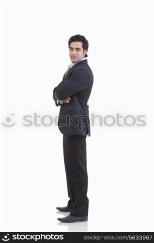 Side view of young businessman in suit standing against white background