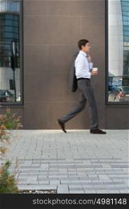 Side view of young businessman walking in passage of office
