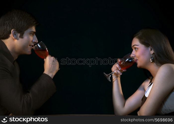 Side view of young couple drinking red wine