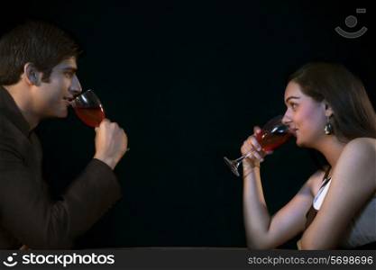 Side view of young couple drinking red wine