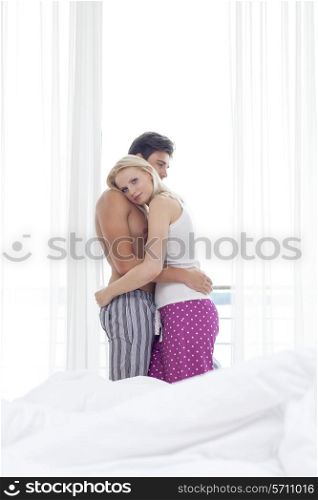 Side view of young couple hugging in hotel room