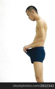 Side view of young man only wearing underwear