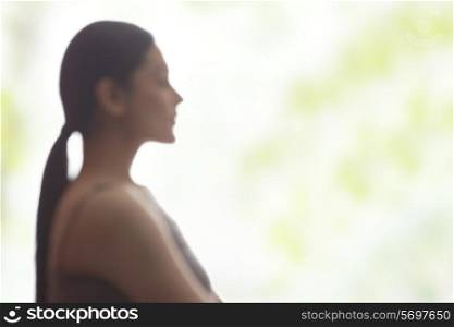Side view of young woman meditating