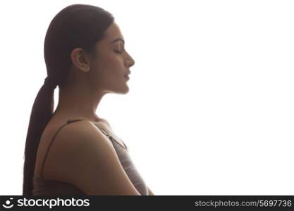 Side view of young woman meditating isolated over white background