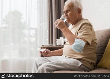 side view old man taking pill