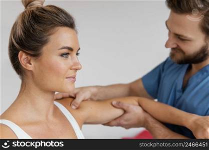 side view osteopathic therapist checking female patient s shoulder