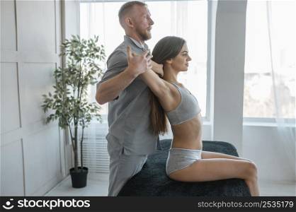 side view physiotherapist doing physical exercises with woman