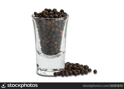 Side view pile of black pepper seeds and black peppers seeds in small glass on white background with clipping path