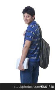 Side view portrait of smiling male student with books and rucksack over white background