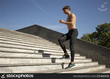 side view shirtless man exercising stairs outdoors