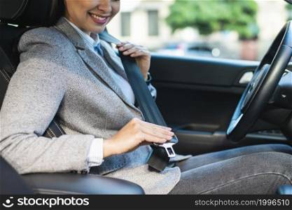 side view smiley businesswoman putting seat belt car