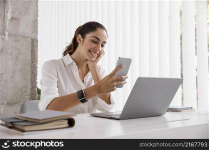 side view smiley businesswoman with smartphone laptop