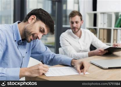 side view smiley man signing work contract