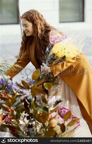 side view smiley woman choosing spring flowers bouquet