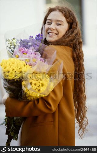side view smiley woman holding spring flowers bouquets