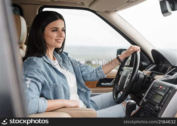 side view smiley woman traveling alone by car