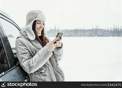 side view smiley woman using smartphone while road trip with copy space