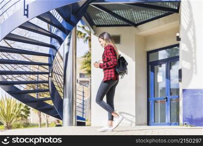 side view teenage female student walking front university building