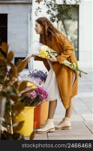 side view woman buying spring flowers outdoors