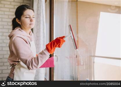 side view woman cleaning window