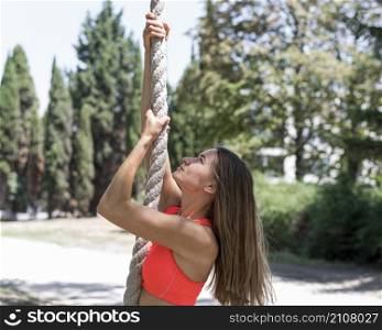 side view woman climbing rope