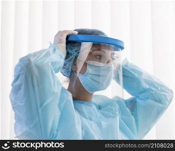 side view woman doctor putting protective wear