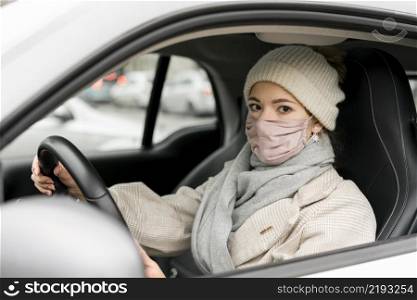 side view woman driving with medical mask