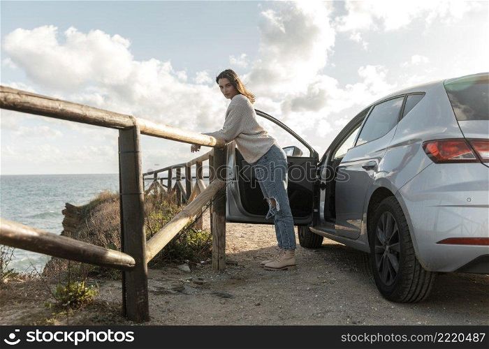 side view woman enjoying view beach from her car