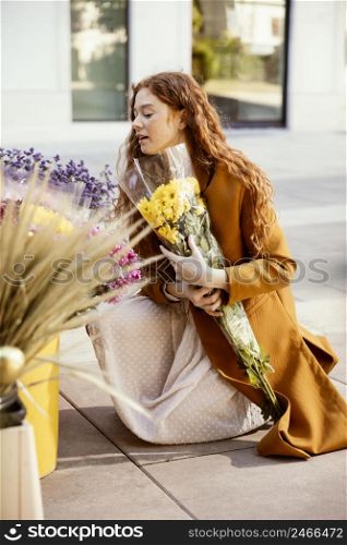 side view woman getting spring flowers outdoors
