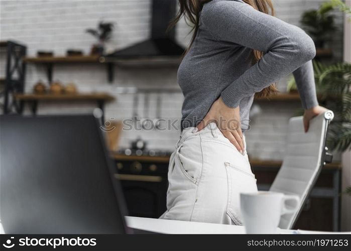 side view woman having backache while working from home. High resolution photo. side view woman having backache while working from home. High quality photo