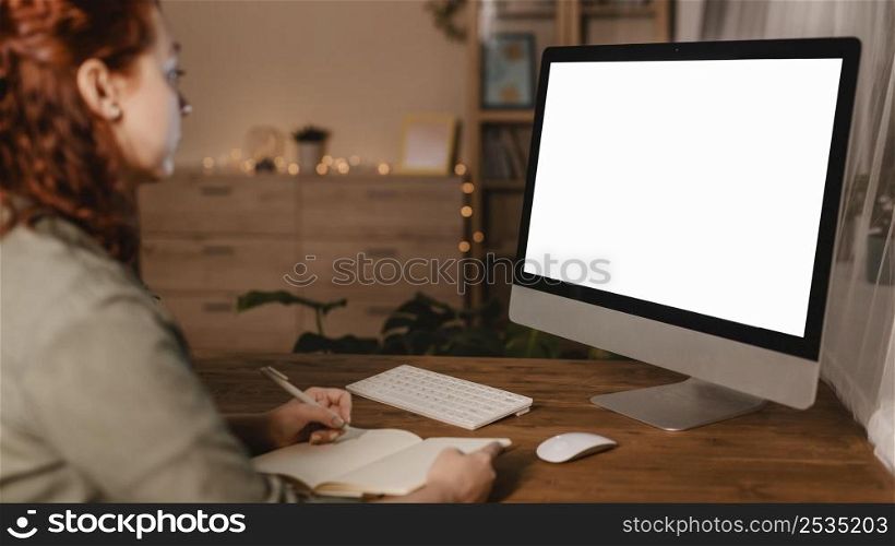 side view woman home using her personal computer