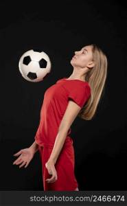 side view woman kicking football ball with cheast