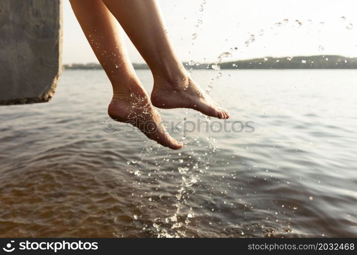 side view woman playing with her feet lake