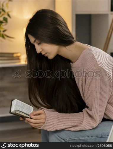 side view woman praying while reading bible