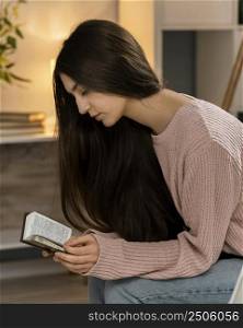 side view woman praying while reading bible