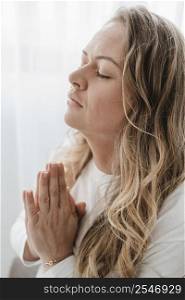 side view woman praying with eyes closed