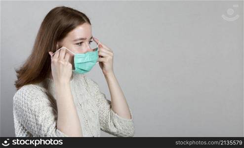 side view woman putting medical mask with copy space