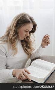 side view woman reading from bible home