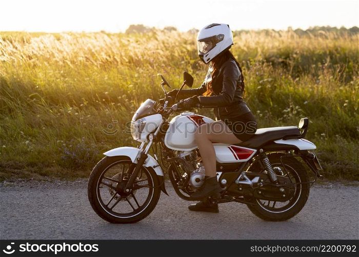 side view woman riding motorcycle with helmet