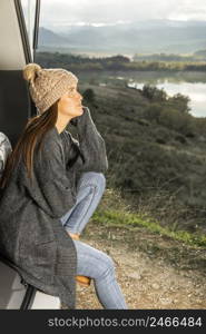 side view woman sitting trunk car while road trip