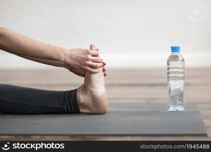 side view woman stretching yoga mat with water bottle. High resolution photo. side view woman stretching yoga mat with water bottle. High quality photo