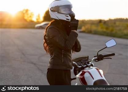 side view woman taking off her helmet motorcycle