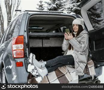 side view woman using smartphone while road trip