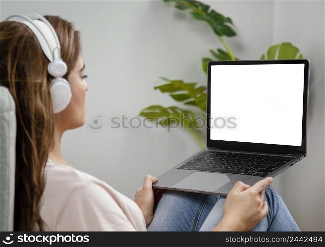 side view woman with headphones using laptop 2