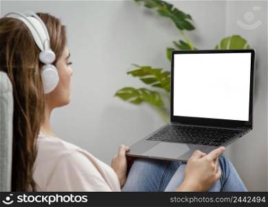 side view woman with headphones using laptop 2