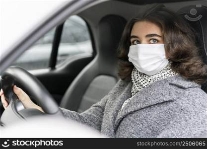 side view woman with medical mask driving car