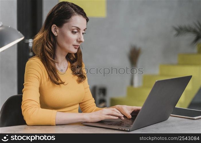side view woman working laptop